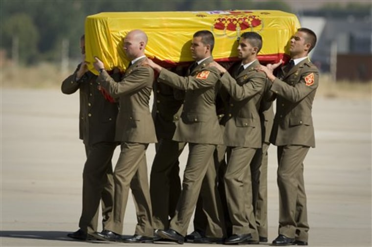Soldiers carry the coffin of Spanish Civil Guards, Jose Maria Galera Cordoba, Leoncio Bravo Picallo and an Iranian-born interpreter Ataola Taefik Alili, at the Torrejon military airbase just outside of Madrid on Thursday, Aug. 26, 2010.  Jose Maria Galera Cordoba, Leoncio Bravo Picallo and Ataola Taefik Alili were killed in Afganistan yesterday August 25. The attack has triggered renewed debate on the presence of 1,500 Spanish soldiers and police in Afghanistan. With the latest attack, 93 have died in connection with the deployment, most of them in air crashes. (AP Photo/Arturo Rodriguez)